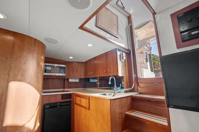 Slide: The Image of 2007 Custom Carolina Layton Express yacht interior with wooden cabinetry and modern kitchen amenities. - 22