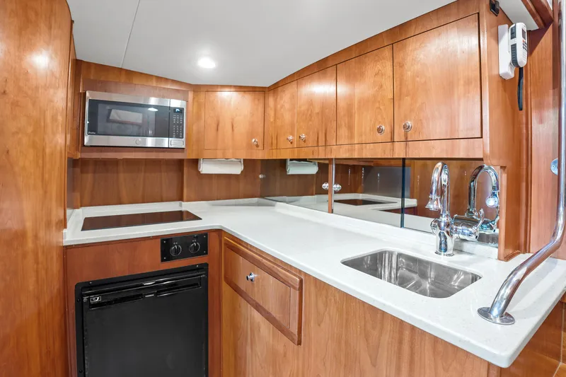 Slide: The Image of Luxurious 2007 Custom Carolina Layton Express yacht kitchen with wood cabinetry and modern appliances. - 23
