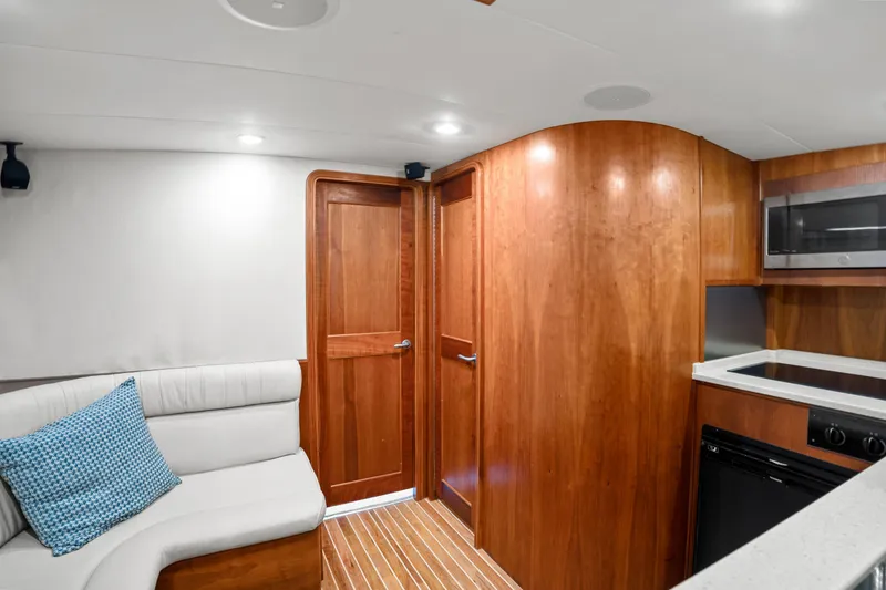 Slide: The Image of 2007 Custom Carolina Layton Express interior with wood cabinetry, white seating, and modern kitchen amenities. - 25