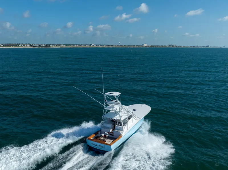 Slide: The Image of 2007 Custom Carolina Layton Express boat cruising on open sea under clear blue sky. - 3