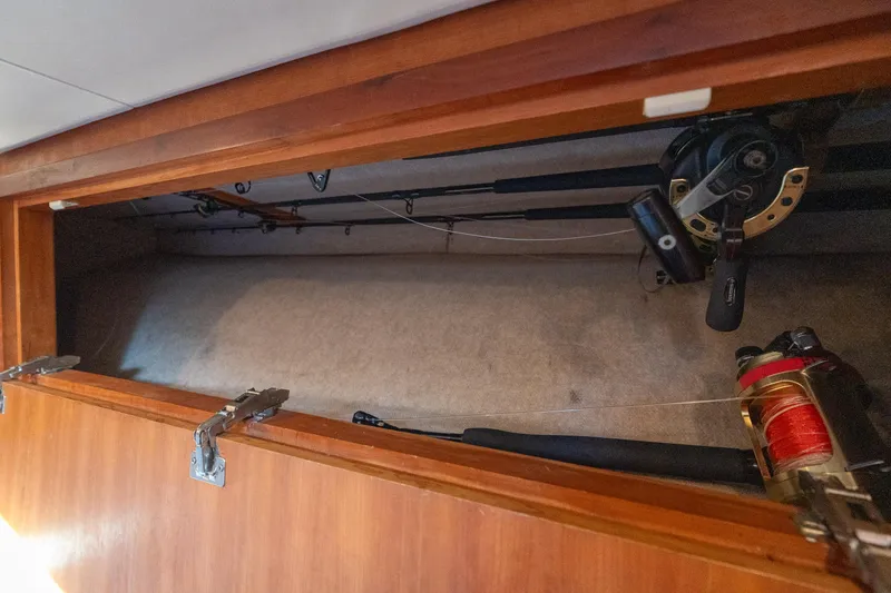 Slide: The Image of Storage compartment with fishing rods in a 2007 Custom Carolina Layton Express boat. - 30