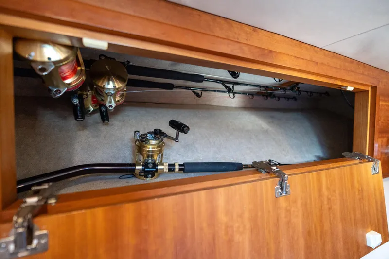 Slide: The Image of Fishing rods and reels stored in a wooden compartment on a 2007 Custom Carolina Layton Express boat. - 31