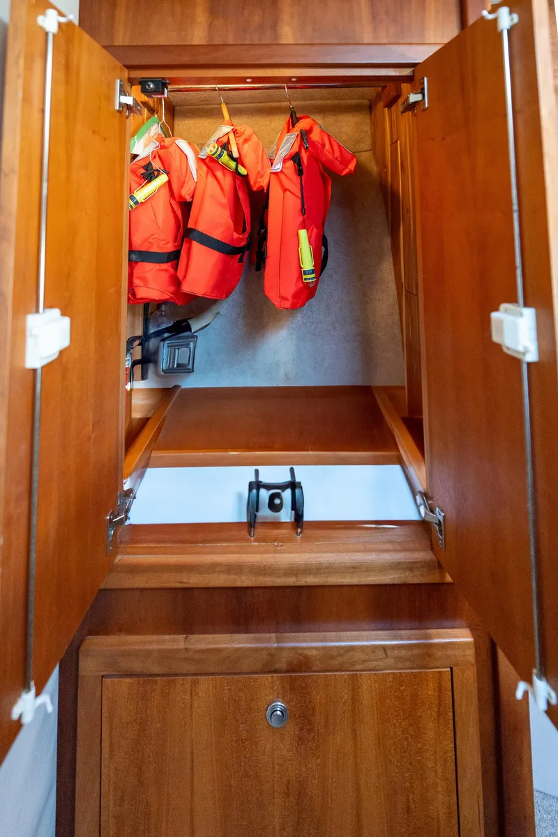 Slide: The Image of Wooden cabinet with life jackets inside, aboard a 2007 Custom Carolina Layton Express. - 32