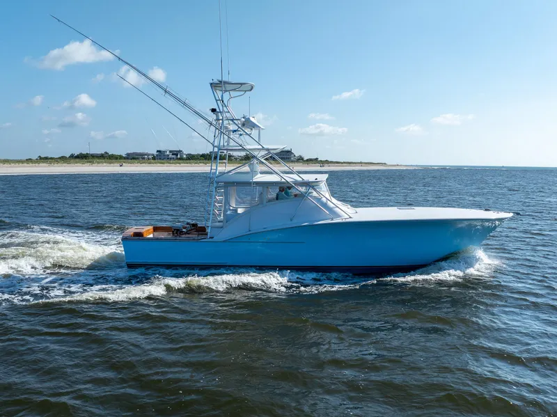 Slide: The Image of 2007 Custom Carolina Layton Express boat cruising on open water under a clear blue sky. - 4