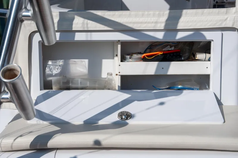 Slide: The Image of Open storage compartment on 2007 Custom Carolina Layton Express boat, containing various items. - 42