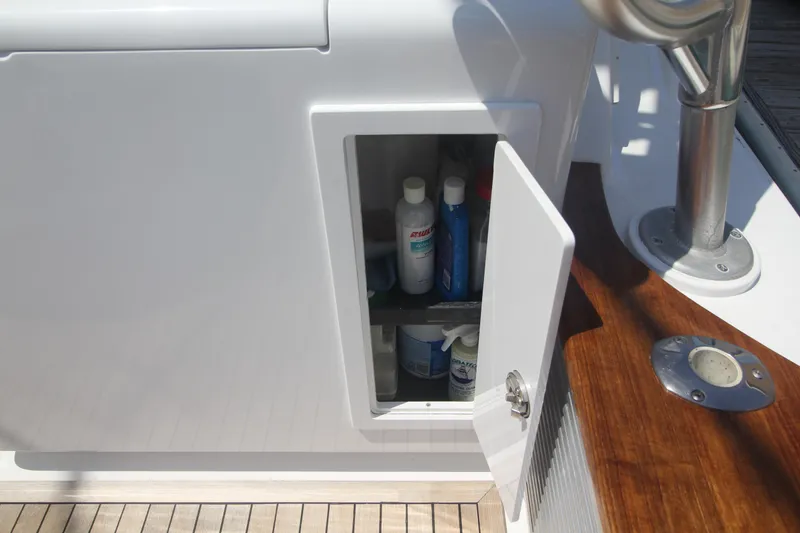 Slide: The Image of Open storage compartment on 2007 Custom Carolina Layton Express boat, containing cleaning supplies. - 45