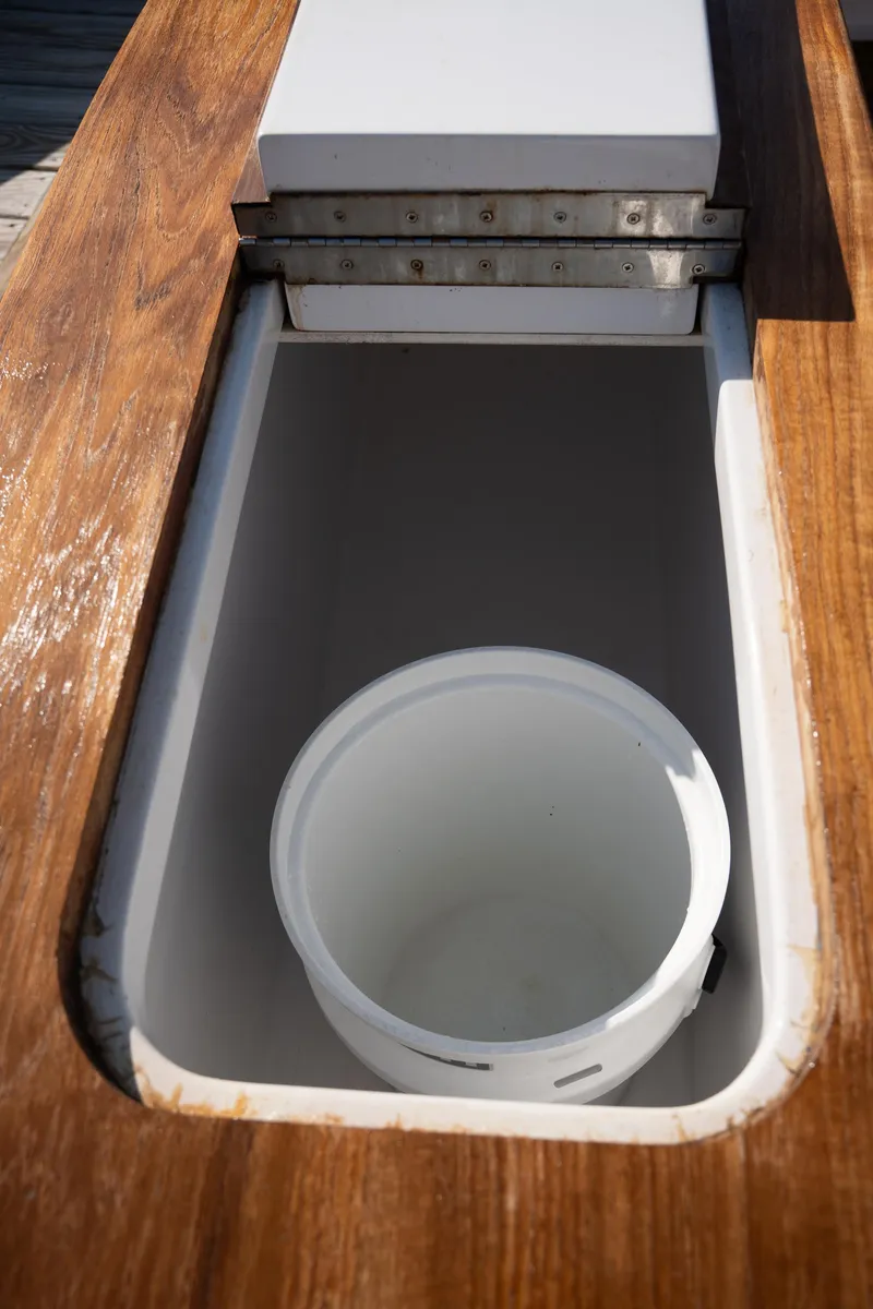 Slide: The Image of Open storage compartment on 2007 Custom Carolina Layton Express boat with wooden trim. - 47