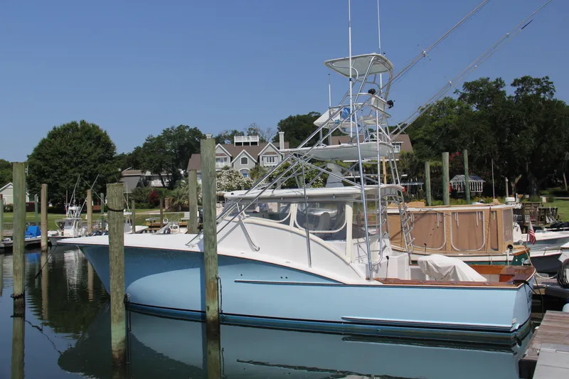 Slide: The Image of 2007 Custom Carolina Layton Express boat docked at a marina, surrounded by trees and houses. - 9
