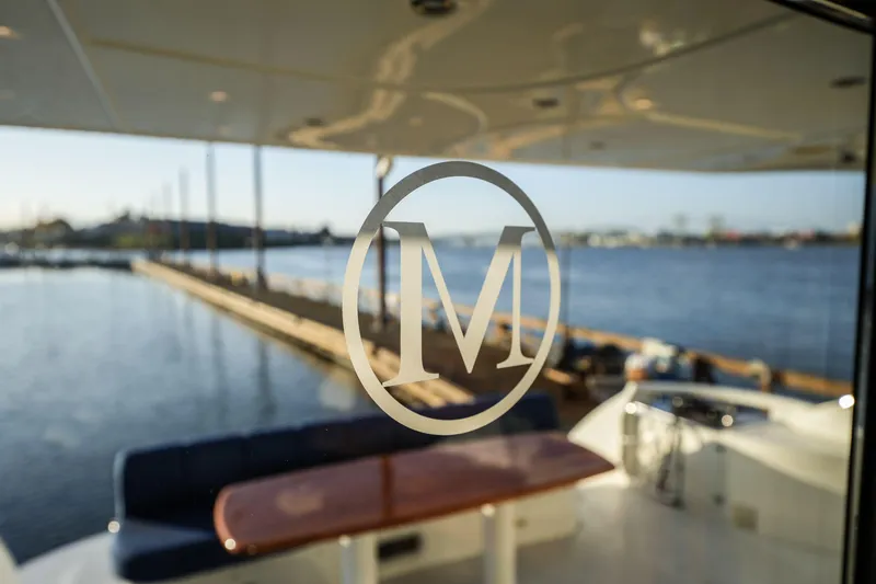 Slide: The Image of Luxury yacht interior with "M" logo, Marquis 65, 2006 model, overlooking serene waterfront. - 12