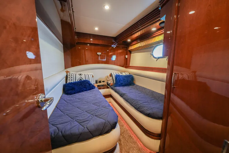 Slide: The Image of Luxurious 2006 Marquis 65 yacht cabin with twin beds, plush pillows, and elegant wood finish. - 24