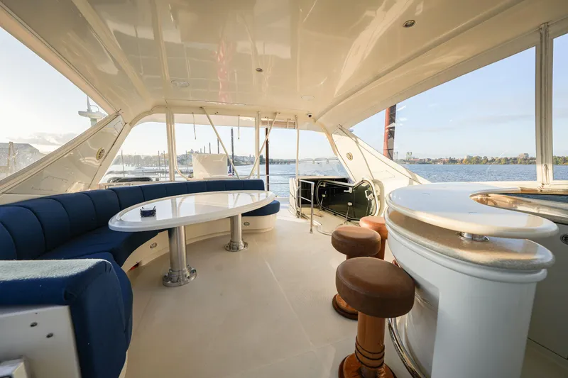 Slide: The Image of Luxurious 2006 Marquis 65 yacht interior with elegant seating and bar area, overlooking serene waters. - 32