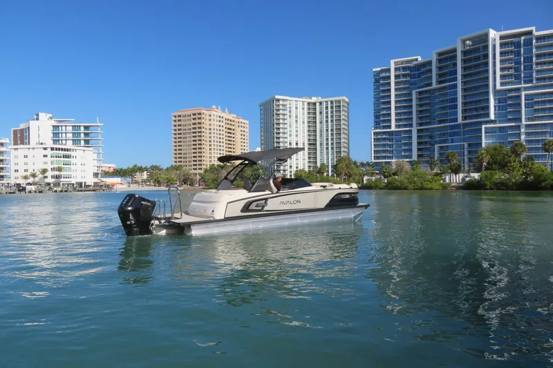 Slide: The Image of 2026 Avalon Excalibur LTD 25’ Tritoon in water, city skyline background, gold/black design. - 98