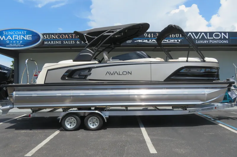 The Image of 2026 Avalon Excalibur LTD 25’ Tritoon on water, cityscape background, sunny day. - 0