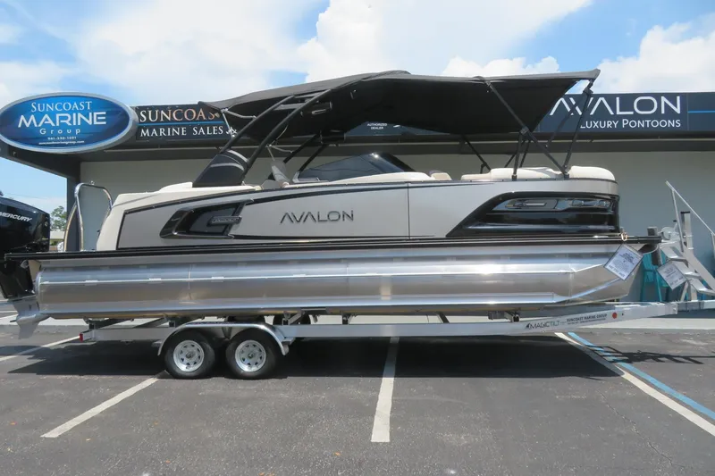 Slide: The Image of 2026 Avalon Excalibur LTD 25’ Tritoon in water, city skyline background, gold/black design. - 4