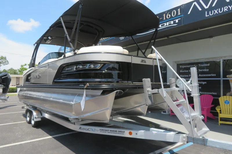 Slide: The Image of 2026 Avalon Excalibur LTD 25’ Tritoon on water, cityscape background, clear blue sky. - 5