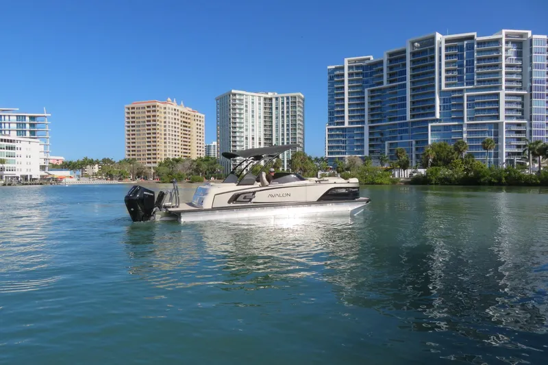 Slide: The Image of 2026 Avalon Excalibur LTD 25’ Tritoon on water, city skyline in background. - 97