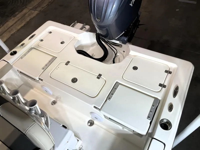 Slide: The Image of 2025 Key West 210 Bay Reef boat deck with storage compartments and outboard motor. - 13