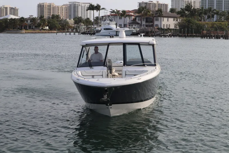 Slide: The Image of 2022 Regal LX36 boat cruising in a scenic waterfront area with city skyline. - 12