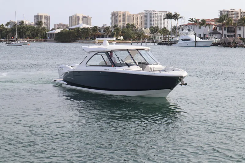 Slide: The Image of 2022 Regal LX36 boat cruising in a scenic waterfront with city skyline. - 3