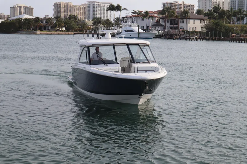 Slide: The Image of 2022 Regal LX36 boat cruising in a scenic waterfront area with buildings in the background. - 7