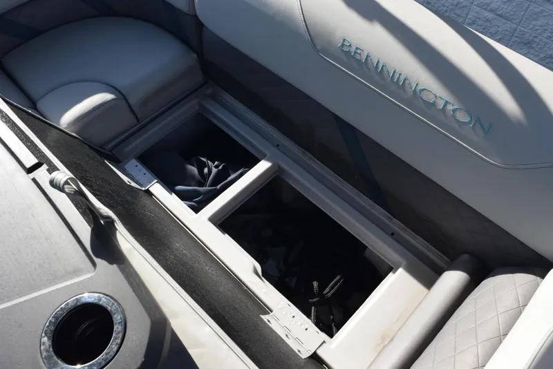 Slide: The Image of 2021 Bennington 18 SLX boat interior storage compartment with open seat and cup holder. - 14