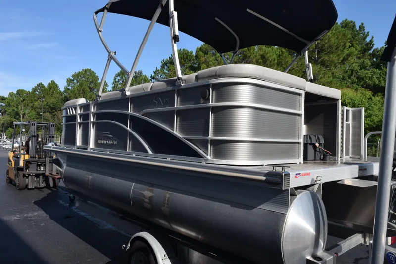 Slide: The Image of 2021 Bennington 18 SLX pontoon boat on trailer, with canopy, in outdoor setting. - 6