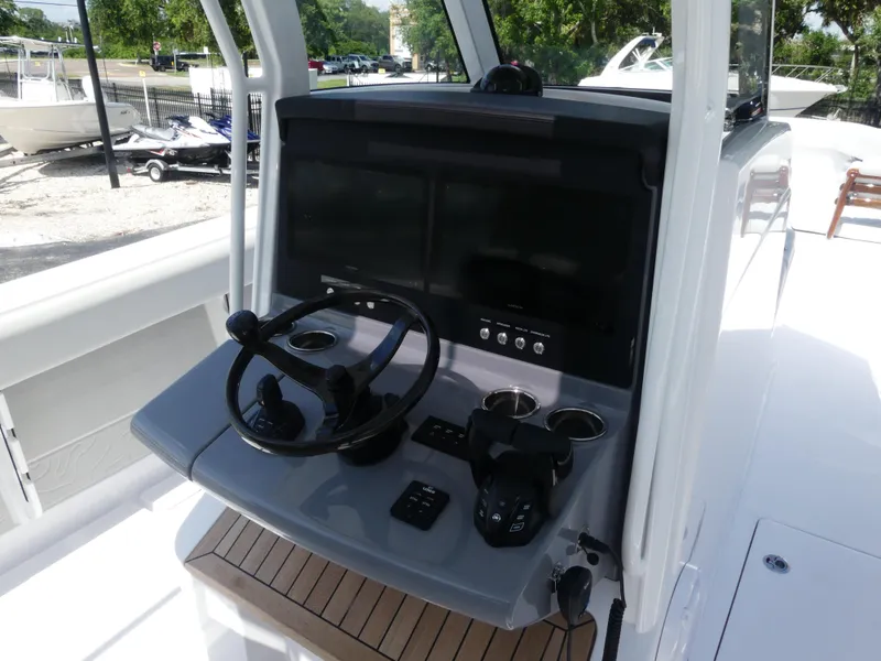 Slide: The Image of 2026 Jupiter 340LS boat console with steering wheel, dual screens, and control panel. - 16