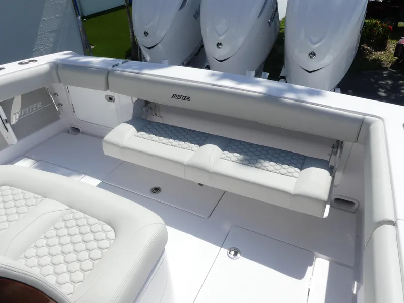 Slide: The Image of 2026 Jupiter 340LS boat interior with white cushioned seating and triple outboard engines. - 23