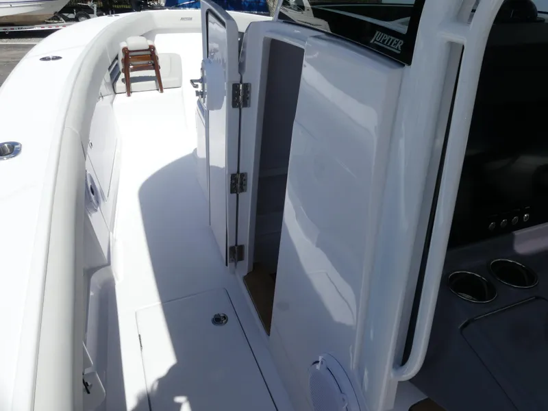 Slide: The Image of 2026 Jupiter 340LS boat interior with open cabin door and seating area. - 29