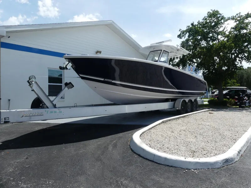 Slide: The Image of 2026 Jupiter 340LS boat on trailer outside building, sunny day. - 3