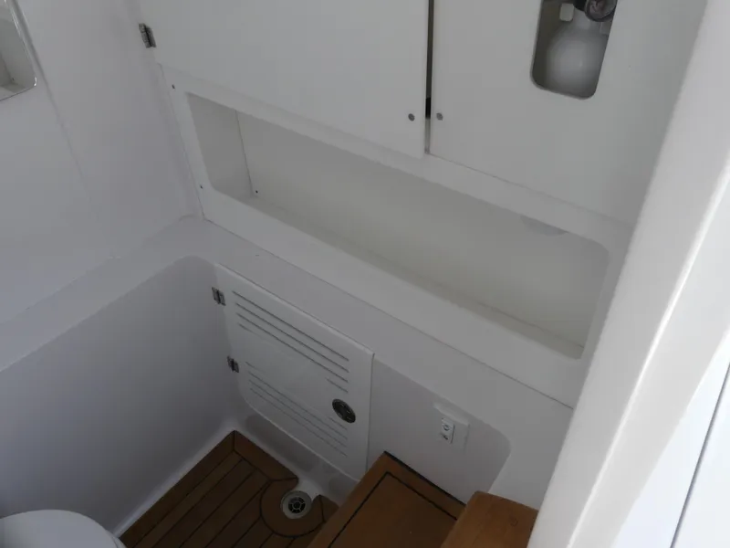 Slide: The Image of 2026 Jupiter 340LS boat interior, featuring white cabinetry and wooden flooring. - 33