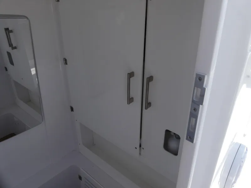 Slide: The Image of Interior of 2026 Jupiter 340LS boat, featuring sleek white cabinetry and modern handles. - 34