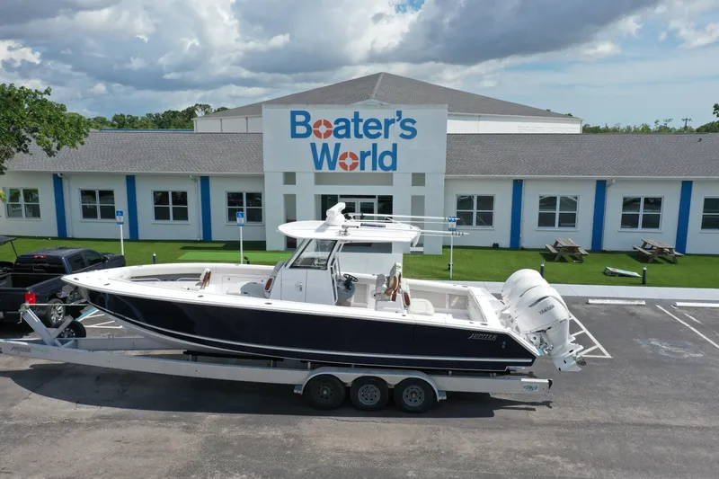 Slide: The Image of 2026 Jupiter 340LS boat on trailer outside Boater's World store under cloudy sky. - 36