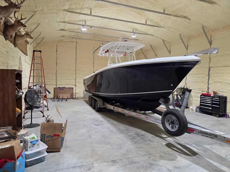 Slide: The Image of 2013 Sailfish 290 CC boat on trailer in spacious garage. - 13