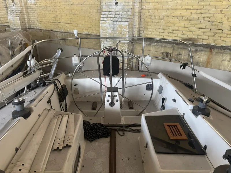 Slide: The Image of 1987 Holby Tripp sailboat interior with steering wheel, ropes, and equipment in a brick-walled storage area. - 17