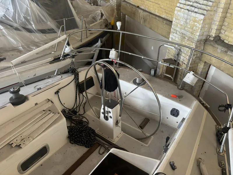 Slide: The Image of 1987 Holby Tripp sailboat interior with steering wheel, ropes, and nautical equipment in storage. - 19