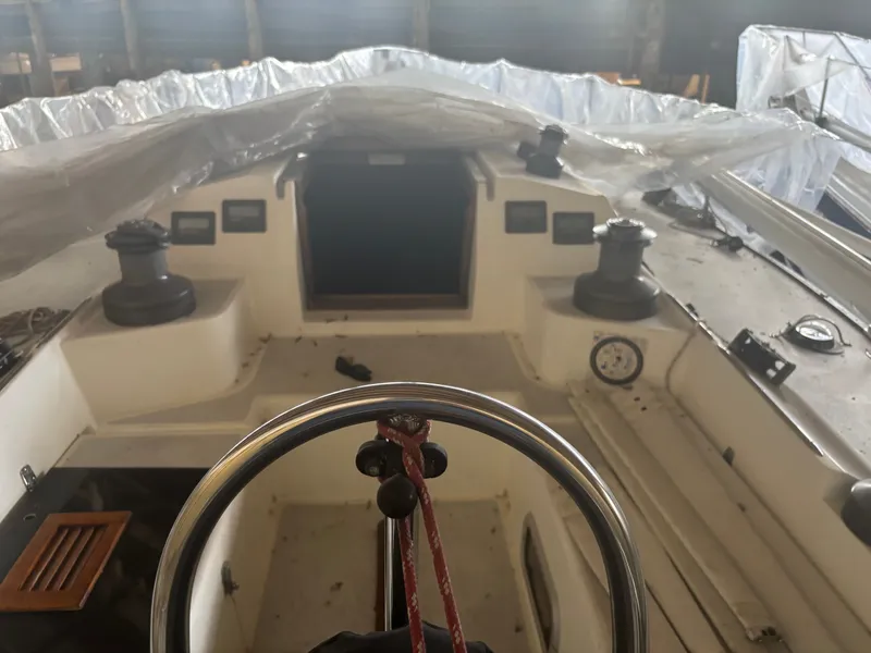 Slide: The Image of 1987 Holby Tripp sailboat cockpit with covered deck, steering wheel, and winches. - 20