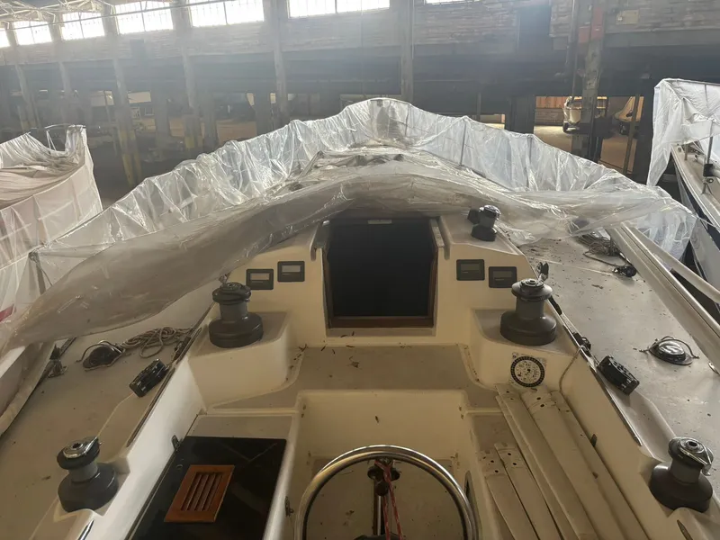 Slide: The Image of 1987 Holby Tripp sailboat in storage, partially covered with plastic sheeting. - 21