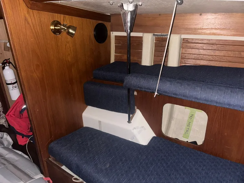 Slide: The Image of Interior of 1987 Holby Tripp sailboat with blue cushioned seating and wooden paneling. - 39