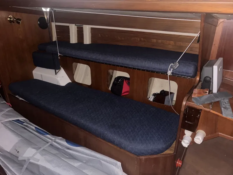 Slide: The Image of Interior of a 1987 Holby Tripp sailboat with blue cushioned bunks. - 40