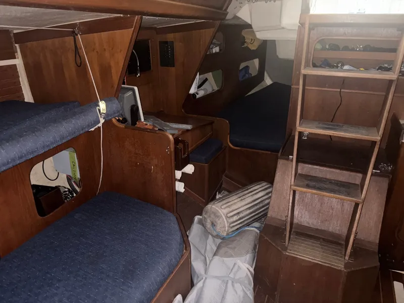 Slide: The Image of Interior of 1987 Holby Tripp sailboat with wooden furnishings and blue cushions. - 42
