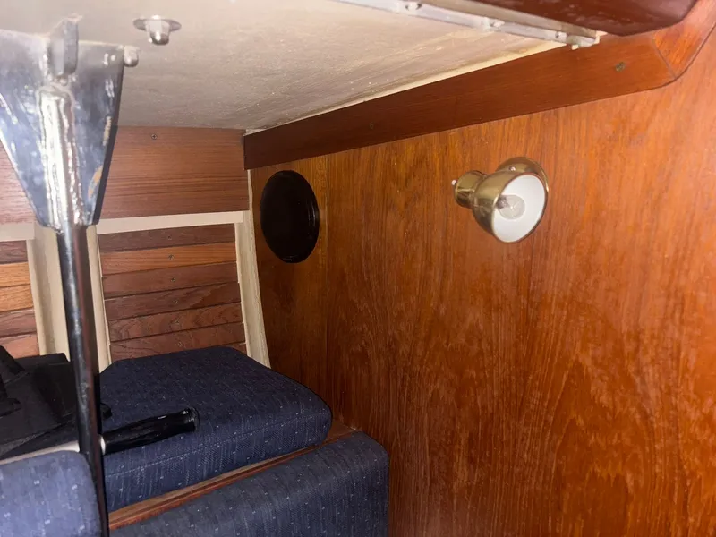Slide: The Image of Interior of a 1987 Holby Tripp boat with wooden paneling and a small light fixture. - 45