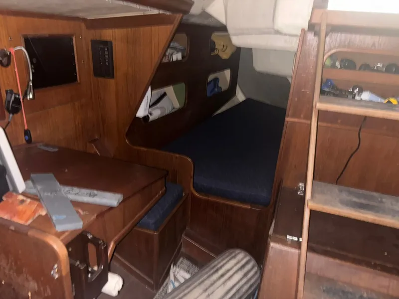 Slide: The Image of Interior of a 1987 Holby Tripp sailboat with wooden furnishings and a cozy sleeping area. - 47