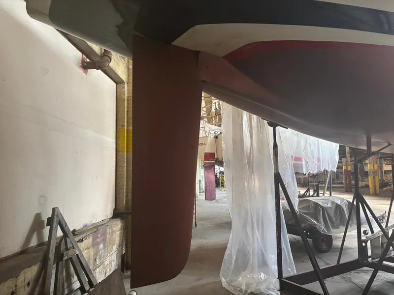 Slide: The Image of 1987 Holby Tripp sailboat in a workshop, showing keel and rudder details. - 6