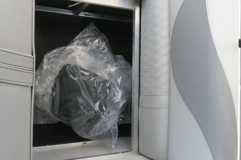 Slide: The Image of 2026 Avalon 2385 LSZ Quad Lounger interior storage compartment with plastic-wrapped item. - 57