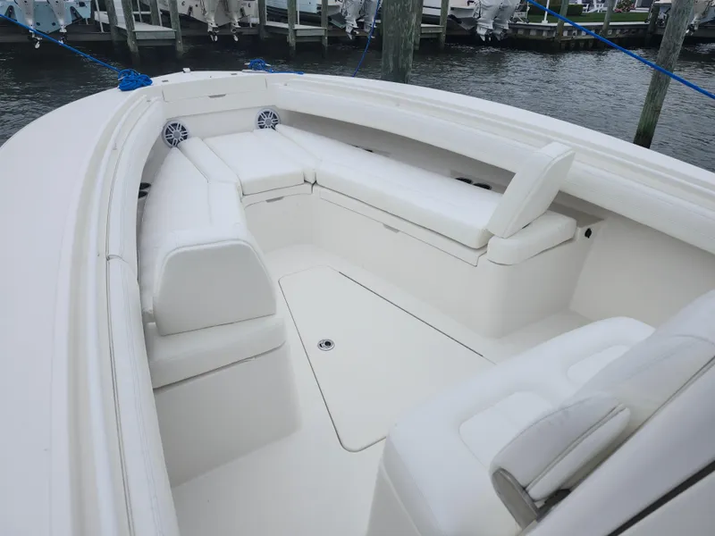 Slide: The Image of 2021 Regulator 25 boat interior with white seating, docked by the water. - 14