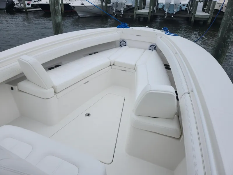 Slide: The Image of 2021 Regulator 25 boat with white seating, docked at a marina. - 15