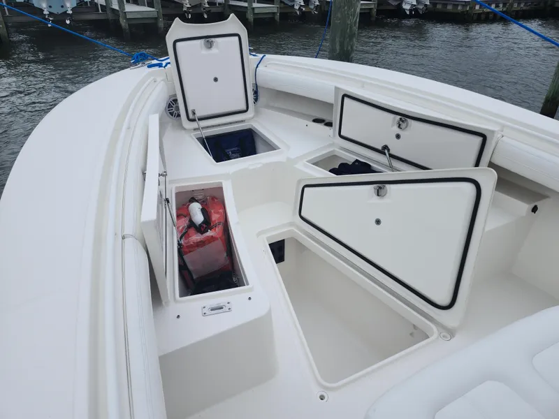 Slide: The Image of 2021 Regulator 25 boat with open storage compartments at the dock. - 16