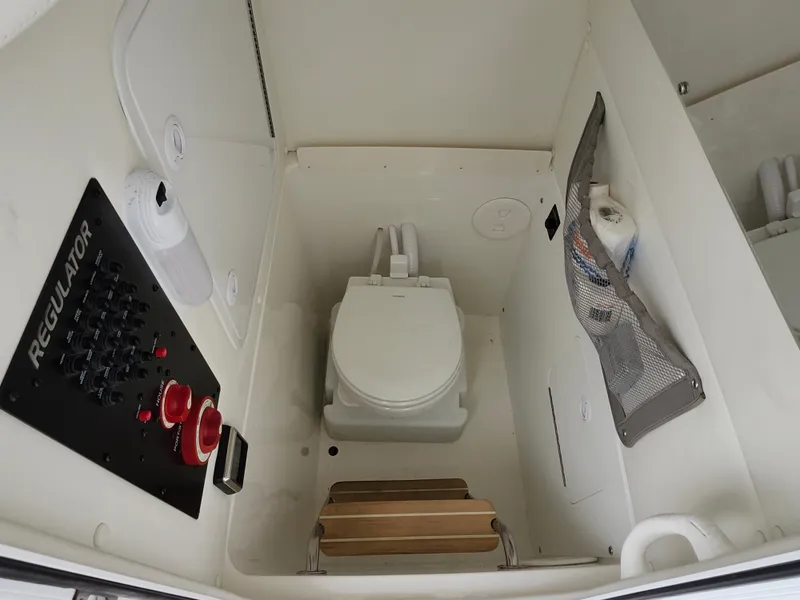Slide: The Image of 2021 Regulator 25 boat interior with toilet and control panel. - 19