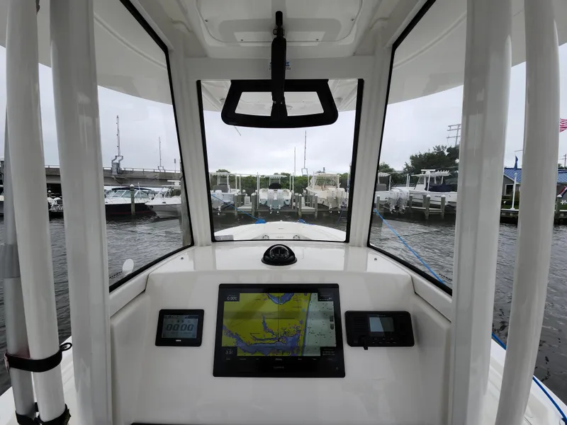 Slide: The Image of 2021 Regulator 25 boat cockpit with navigation screens, docked at marina. - 9